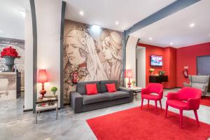a living room with a couch and two red chairs at Rossio Garden Hotel in Lisbon