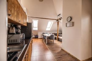 a kitchen with a table and a clock on the wall at Family Tree rekreačný dom in Liptovský Mikuláš