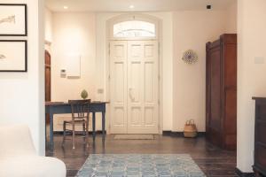 a hallway with a white door and a desk at Spighe e Fenicotteri in Modica +24 photos