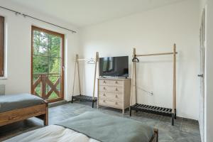 a bedroom with a bed and a tv on a dresser at Ubytování Za Humny in Velké Kunětice