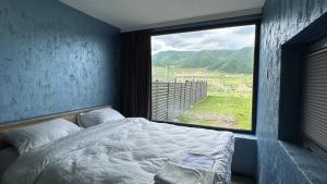 a bedroom with a bed and a large window at Shahdag Berghoff House in Qusar +79 photos