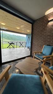 a room with two chairs and a table and a large window at Shahdag Berghoff House in Qusar