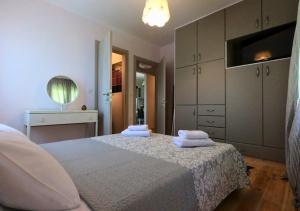 a bedroom with a bed with two towels on it at Peonia Flower House in Asprogerakata