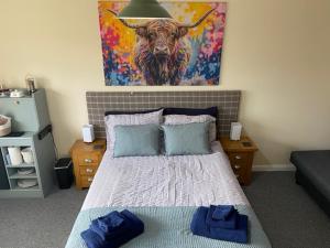 サースクにあるHeads In Beds, The Bull Roomのベッドルーム1室(牛の絵画が壁に描かれたベッド1台付)