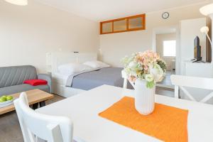 a white vase with flowers on a table in a room at Weitblick in Burgtiefe auf Fehmarn 