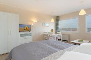 a bedroom with a bed and a kitchen and a table at Weitblick in Burgtiefe auf Fehmarn  +9 photos