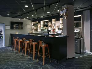 a bar with brown stools in a restaurant at Scandic Aarhus Vest in Aarhus