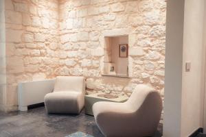 a living room with two chairs and a mirror at Spighe e Fenicotteri in Modica