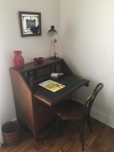 einen Schreibtisch mit einer Lampe und einem Stuhl in einem Zimmer in der Unterkunft T2 plein centre-ville, Gare à 5 min, Près Ermitage in Maisons-Laffitte