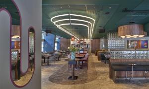 a restaurant with green ceilings and tables and chairs at Scandic Malmen in Stockholm