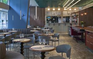 a restaurant with tables and chairs and a blue wall at Scandic Malmen in Stockholm
