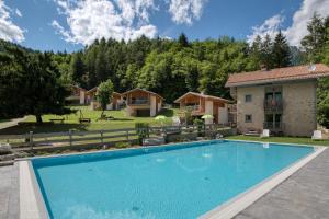 ein Swimmingpool vor einem Haus in der Unterkunft VILLAGGIO VAL MOLINI in Ledro