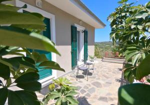 a patio of a house with two chairs and a window at Peonia Flower House in Asprogerakata