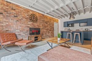 - un salon décloisonné avec un mur en briques dans l'établissement Iron Haven - Central B'ham - Luxury Apt, à Birmingham