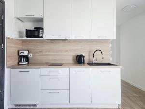 サルビノボにあるApartament Fala by BALTIC CLUB - 300m od Plażyの白いキッチン(白いキャビネット、シンク付) +4枚の写真