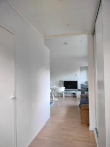 a hallway leading to a living room with white walls at Apartment & BBQ & free parking in Espoo