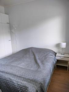 a bedroom with a bed and a table with a lamp at Apartment & BBQ & free parking in Espoo