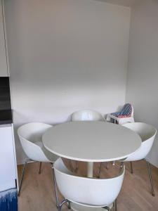 a white table and chairs in a room at Apartment & BBQ & free parking in Espoo