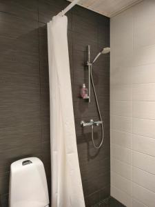 a shower with a white shower curtain in a bathroom at Apartment & BBQ & free parking in Espoo