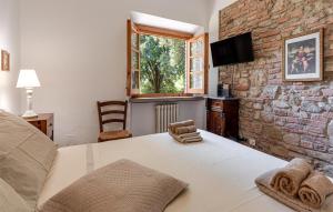 ガンバッシ・テルメにあるVilla Dei Tigliのベッドと石の壁のある寝室