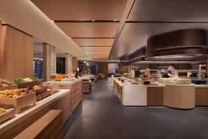 a kitchen with people preparing food in a restaurant at Beijing Marriott Hotel Yanqing in Yanqing
