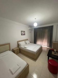 Una habitación de hotel con dos camas y una ventana. en Hotel Fabio, en Tirana