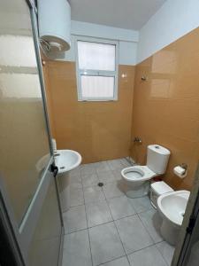 un baño con inodoro y lavabo en Hotel Fabio, en Tirana