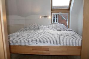 una cama en una habitación con ventana en Residenz Rosengrund WHG D6, en Büsum 17 fotos más