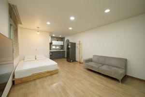 a bedroom with a bed and a couch in it at Boryeong Daecheon Favorite Pension in Boryeong