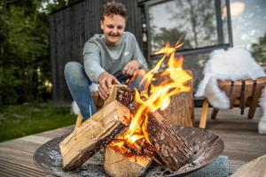 a man sitting in front of a fire at Twente Cabin Hezingen in Hezingen