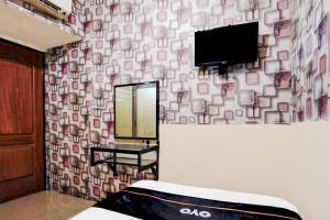 a room with a mirror and a tv on a wall at Hotel O Surabaya near Universitas Airlangga formerly Kertajaya Residence Surabaya in Bagongsabrangan