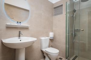 a bathroom with a sink and a toilet and a mirror at Kokkari Beach Hotel in Kokkari +37 photos