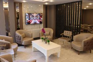 a waiting room with chairs and a table and a tv at Nif Ankara Hotel in Yenişehir