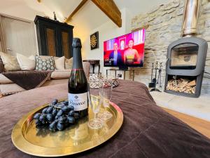 eine Flasche Wein auf einem Tisch mit Weingläsern in der Unterkunft Pass the Keys Stunning 3-Bed Cottage Shepherd Hut Peak Views in Castleton