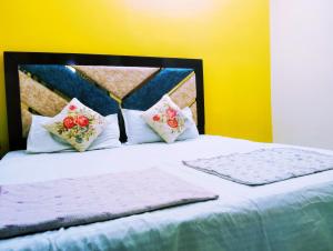 un letto con due cuscini sopra di "Om Sadan" Guest House Ayodhya Dhaam a Ayodhya