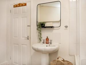 a white bathroom with a sink and a mirror at Pass the Keys Bright & Cosy Home with Garden Free Parking in Nottingham +33 photos
