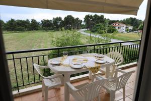 a white table and chairs on a balcony at seasideepanomi in Epanomi
