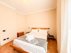 un dormitorio con una cama con sábanas blancas en Violeta's Apartment Golem, en Polisi i Vogël