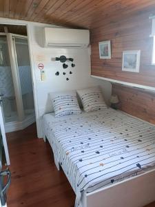 a bed in a room with a wooden ceiling at PENICHE FARNIENTE CLIMATISEE - Aux Portes de la Camargue in Bellegarde +28 photos