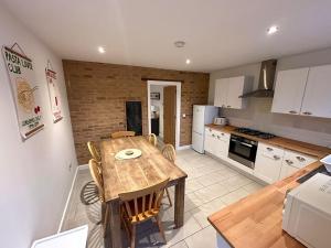 a kitchen with a wooden table and a dining room at 8 - Mouse Hole - Vast dog friendly garden with hot tub in Sparham