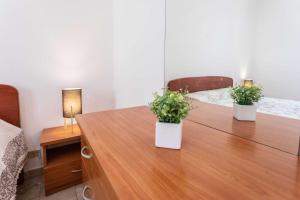 Lido ConchigliaにあるVilletta Bouganville - Salento Reservationの木製テーブル(植物2本付)