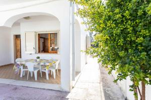 Lido ConchigliaにあるVilletta Bouganville - Salento Reservationの白い家(テーブル、椅子付)