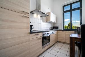 a kitchen with wooden cabinets and a stove top oven at InselLiebe mit Seeterrasse in Malchow +14 photos