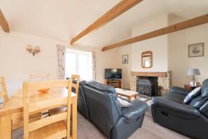 a living room with a couch and a table at Buckingham Cottage - Lancombes House in Powerstock