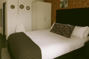 een slaapkamer met een wit bed met een kussen erop bij Charming apartment With Private Balcony in Johannesburg +28 foto's