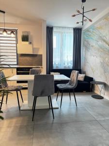 a living room with a table and chairs at Modern Apartment in Dumbrăviţa