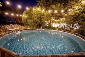 a swimming pool at night with lights at Ambra - Luxury & Big Apartment with Garden & Pool in Casamassella