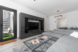 salon z szarą kanapą i dużym telewizorem w obiekcie Casa Diamante - Estepona w mieście Estepona