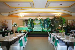 a banquet hall with tables with green and white decorations at Bohol Plaza Mountain Resort and Restaurant in Dauis