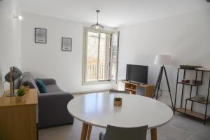 ein Wohnzimmer mit einem Tisch und einem Sofa in der Unterkunft Citadella Calvi confort chaleureux et climatisé in Calvi